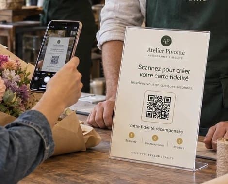Support QR du programme de fidélité posé sur le comptoir d’un fleuriste, scanné par une cliente