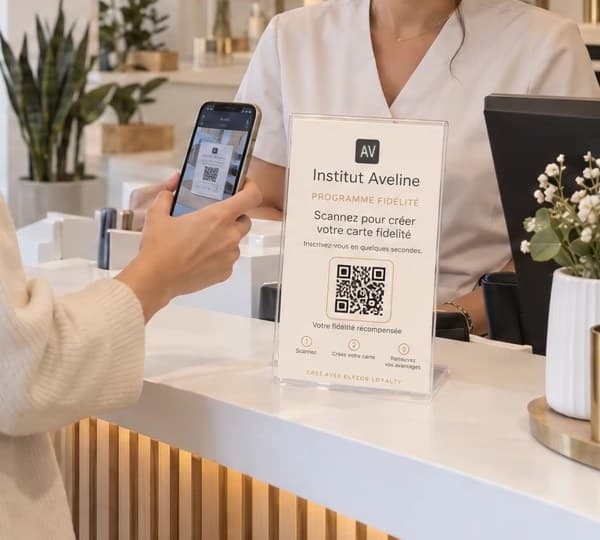 Support QR du programme de fidélité posé sur le comptoir d’accueil, scanné par une cliente