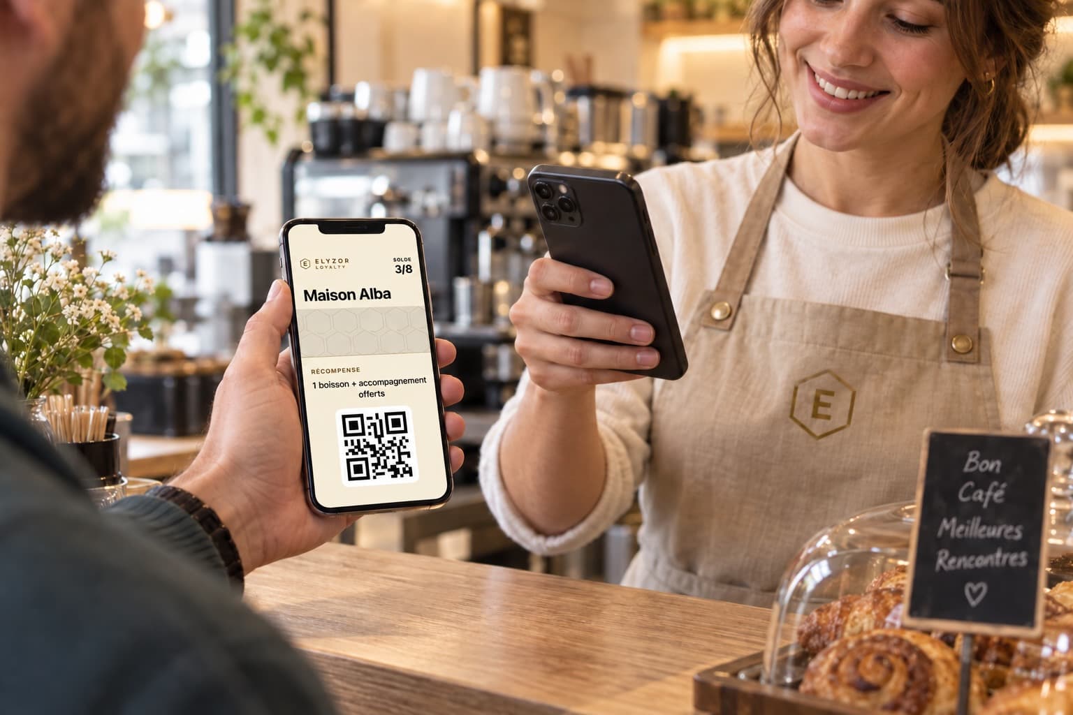 Un client présente sa carte de fidélité Maison Alba sur son téléphone, au comptoir d’un café.
