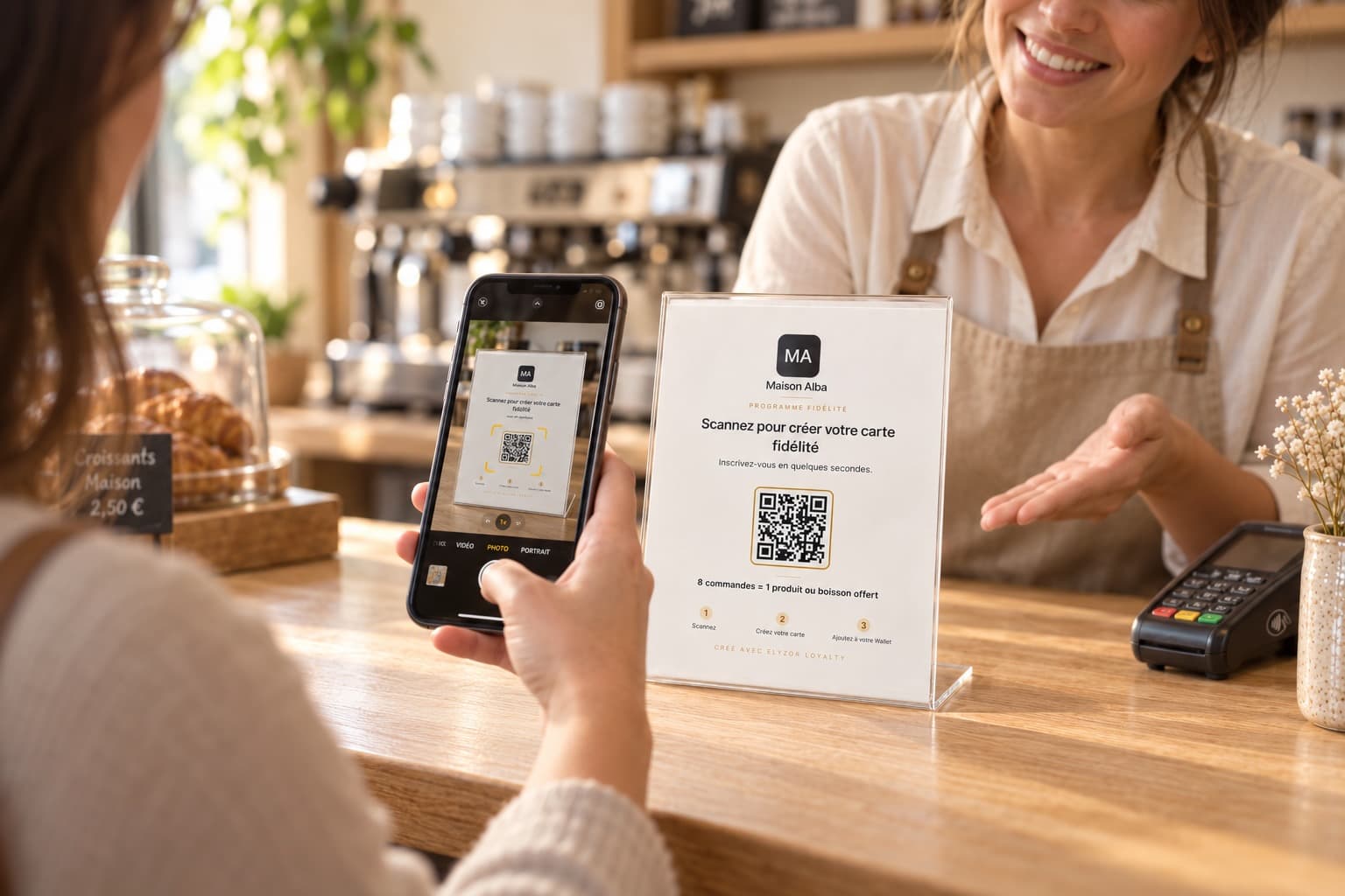 Téléphone scannant le QR code du support ELYZOR posé sur un comptoir